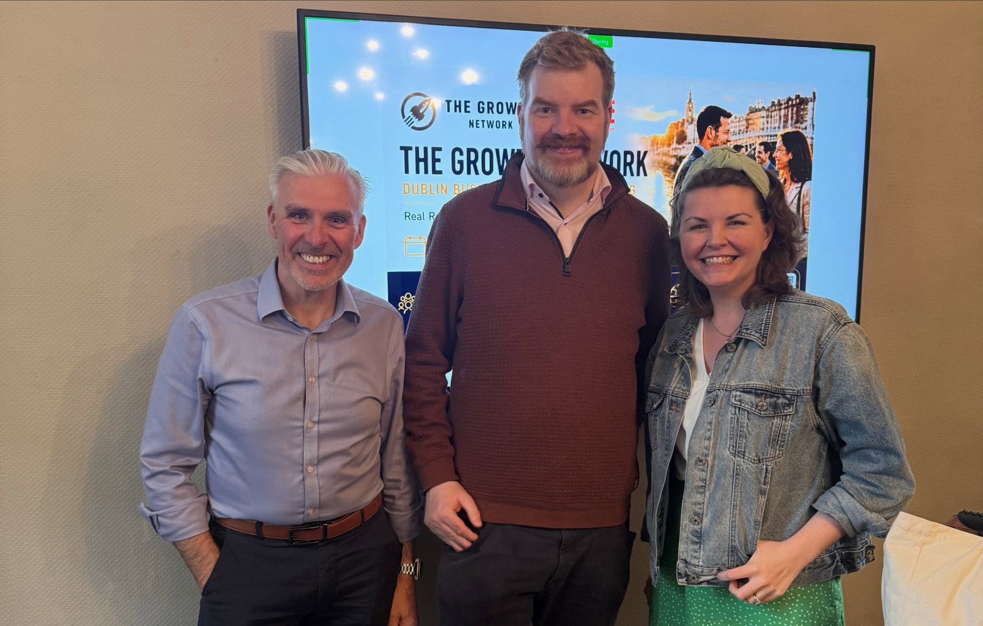 Martin Murtagh with two Growth Network members in front of a Growth Network Dublin event screen
