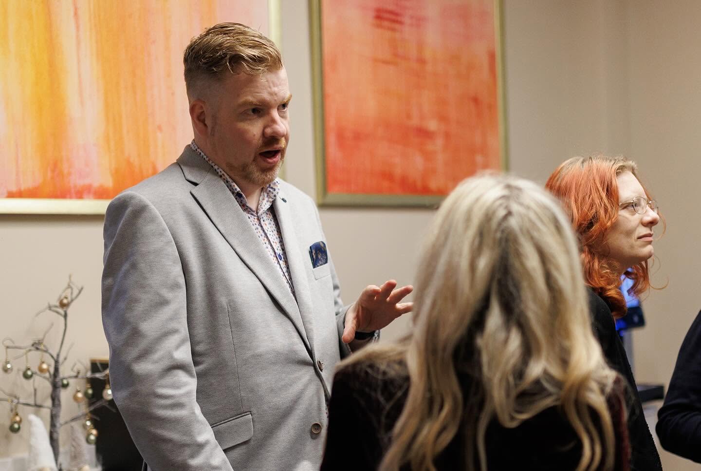 Martin Murtagh in a grey blazer speaking to a small group at a business gathering
