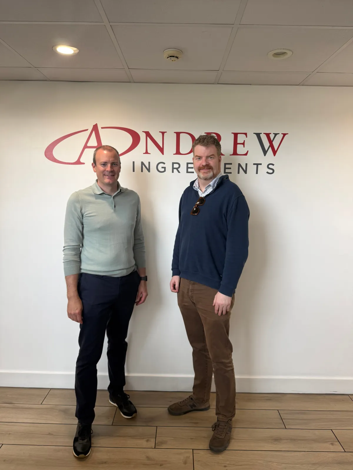 Martin Murtagh standing with a man in front of the Andrew Ingredients sign in an office